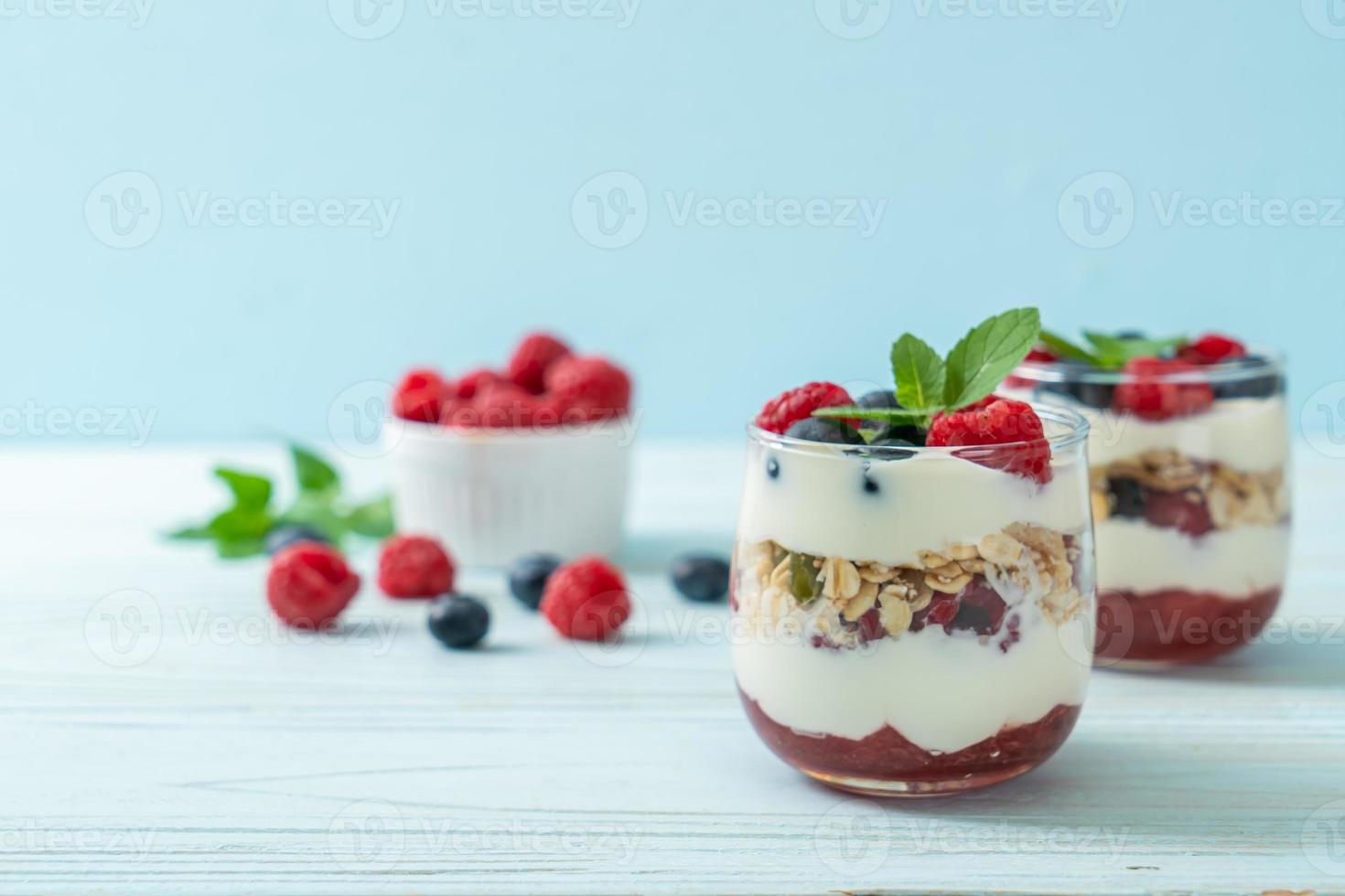 hausgemachte Himbeeren und Heidelbeeren mit Joghurt und Müsli - gesunder Ernährungsstil foto