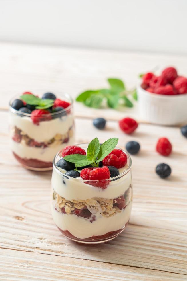 hausgemachte Himbeeren und Heidelbeeren mit Joghurt und Müsli - gesunder Ernährungsstil foto