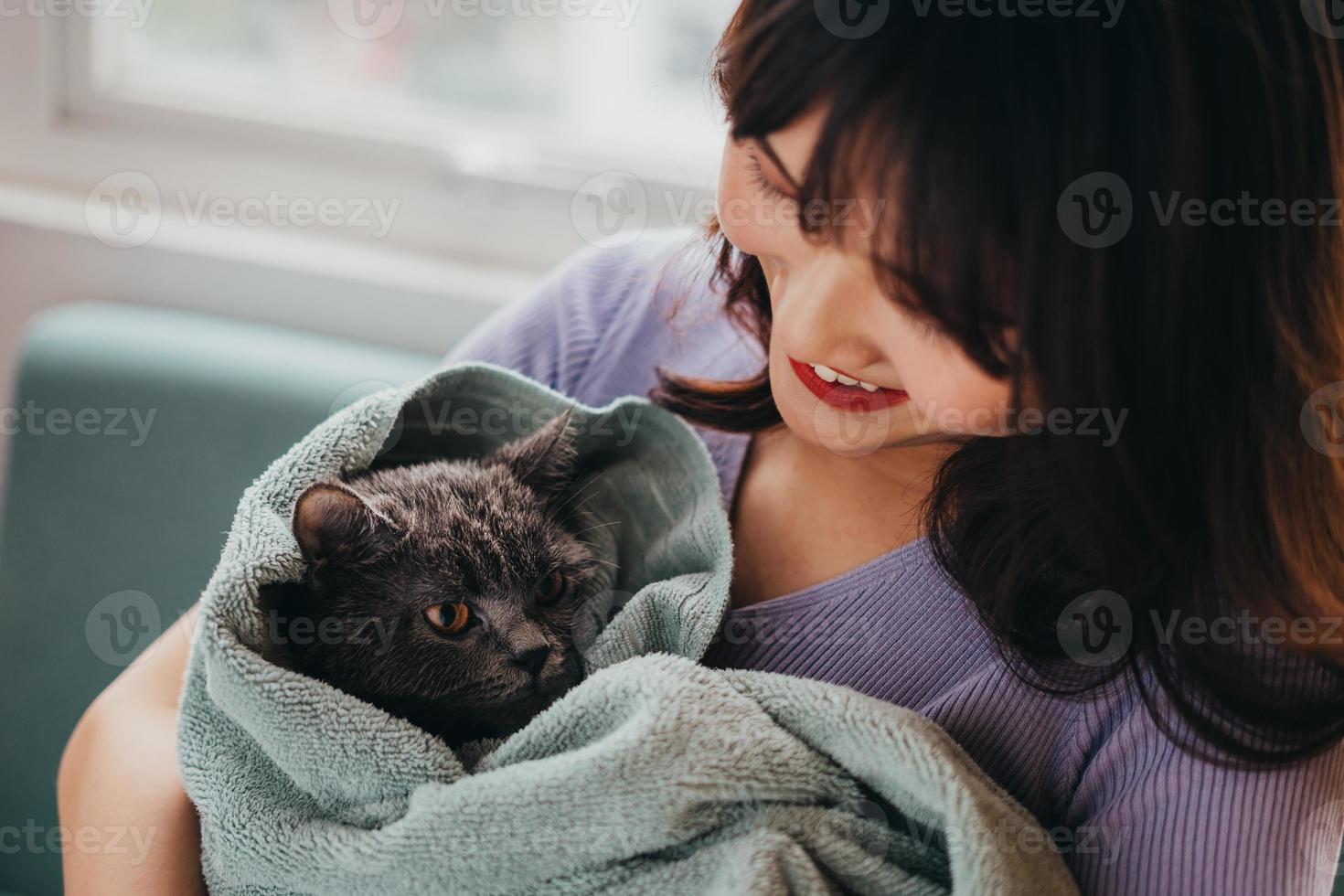 das schöne Mädchen trocknete das Fell ihrer Katze foto