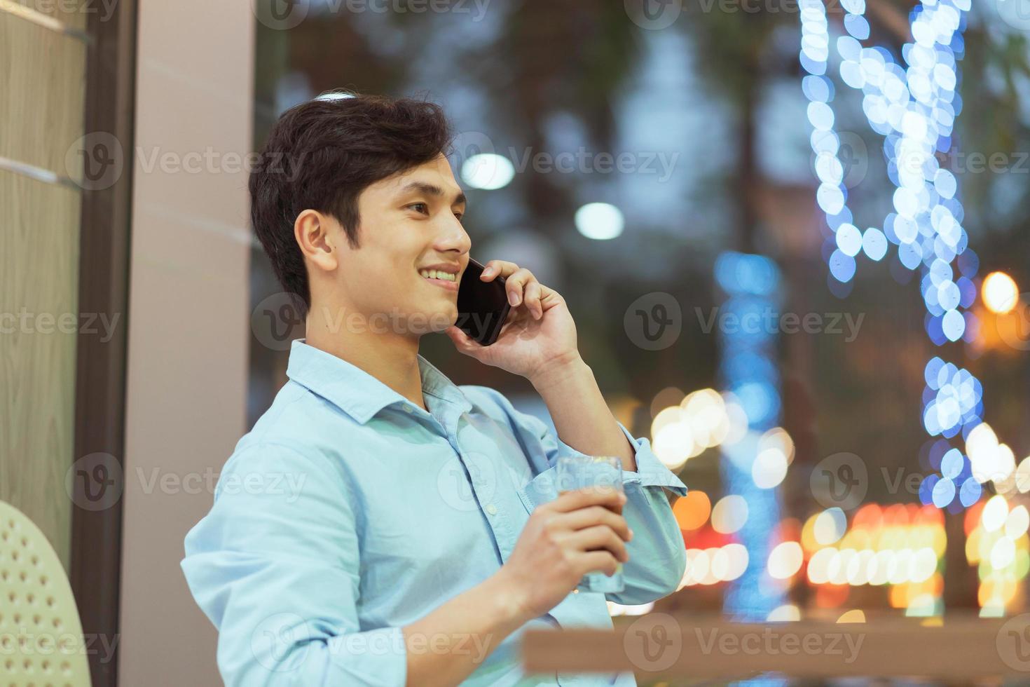 asiatischer Mann, der allein in einem Café sitzt foto