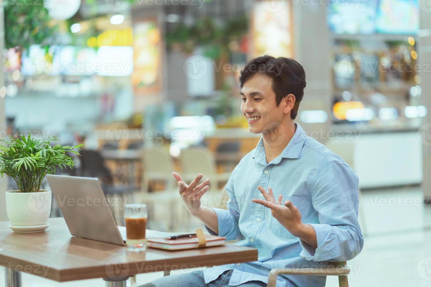 asiatischer Mann, der allein in einem Café sitzt foto