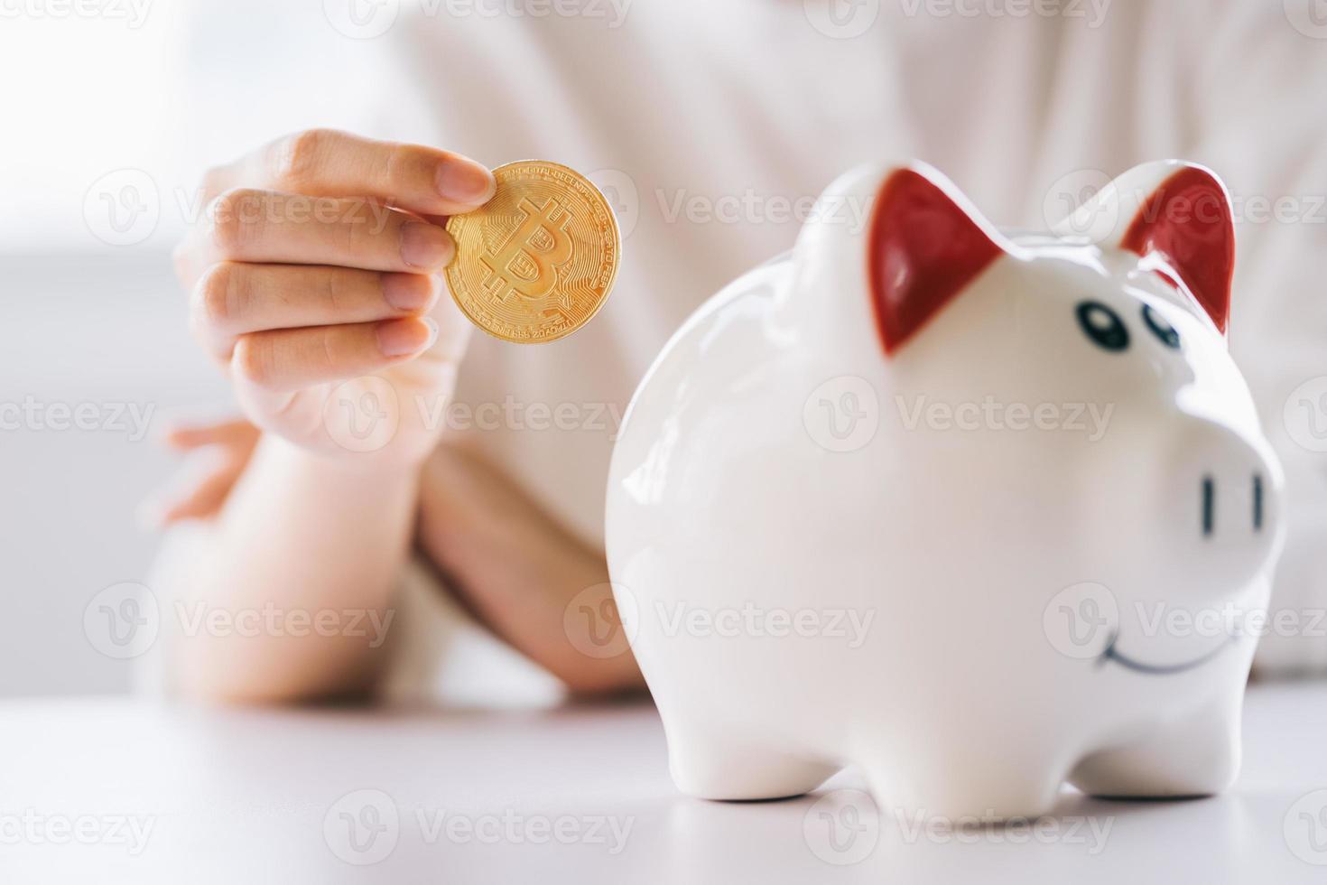 Frauenhand, die Münze hält, um das Sparschwein auf den Tisch zu legen, Geld und Finanzinvestitionen zu sparen foto
