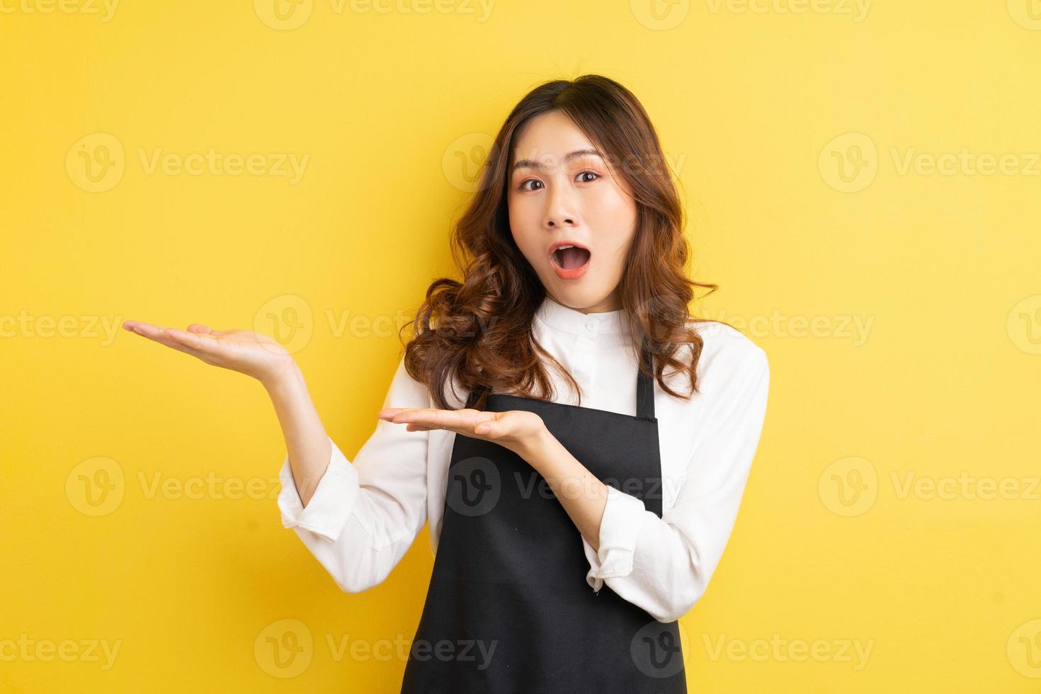 schöne Hausfrau mit Geste isoliert auf gelbem Hintergrund foto