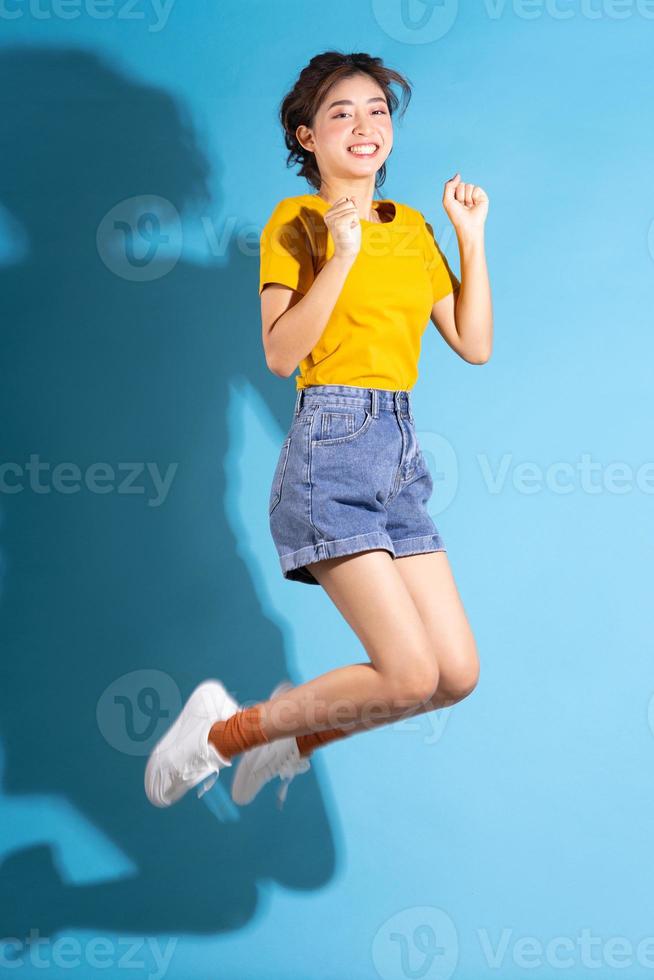 junge Asiatin posiert auf blauem Hintergrund foto
