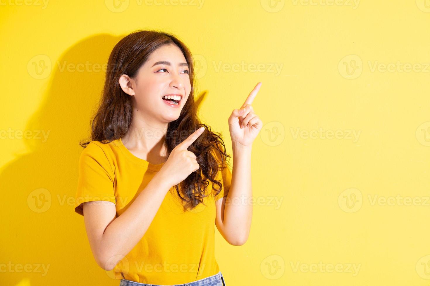 junges asiatisches mädchen posiert auf gelbem hintergrund foto