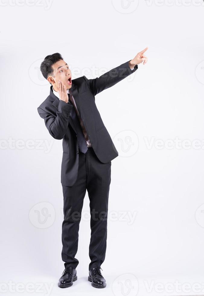 junger asiatischer Geschäftsmann, der auf weißem Hintergrund steht foto