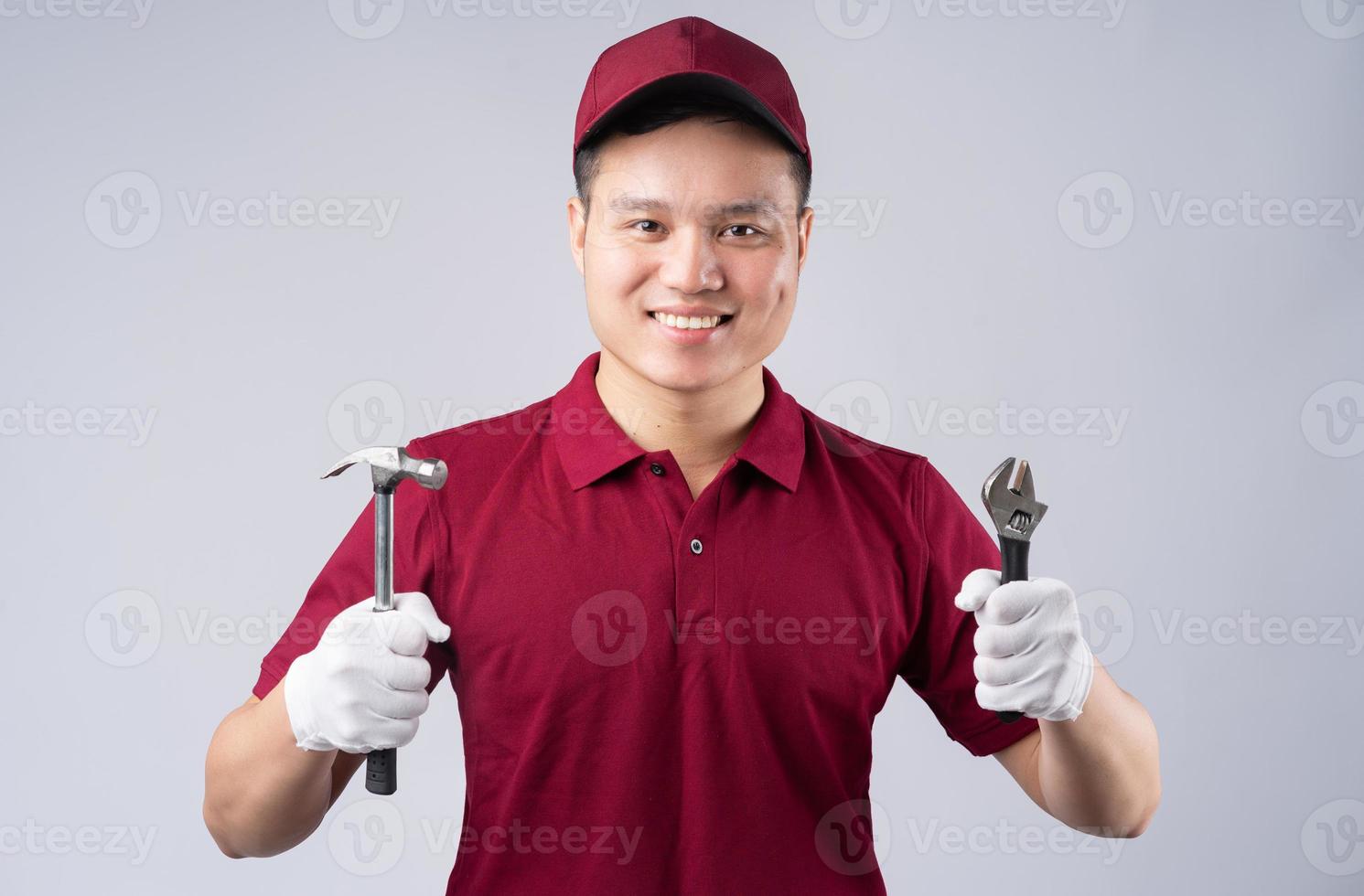 Bild des asiatischen Mechanikers auf grauem Hintergrund foto
