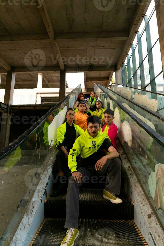 ein Gruppe von asiatisch Männer sind entspannend auf das Treppe mit ihr freunde beim ein Universität foto