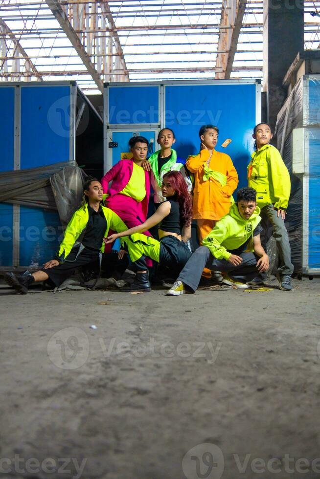 ein Gruppe von asiatisch Fröhlich Männer posieren um ein verlassen Gebäude mit ihr freunde foto