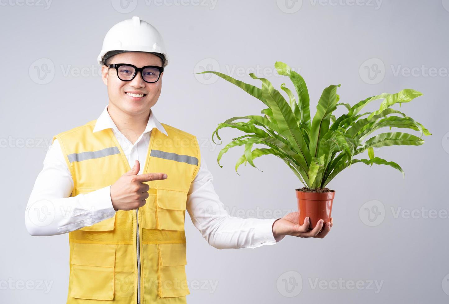 Bild eines asiatischen Ingenieurs, der Topfpflanzen in der Hand hält foto