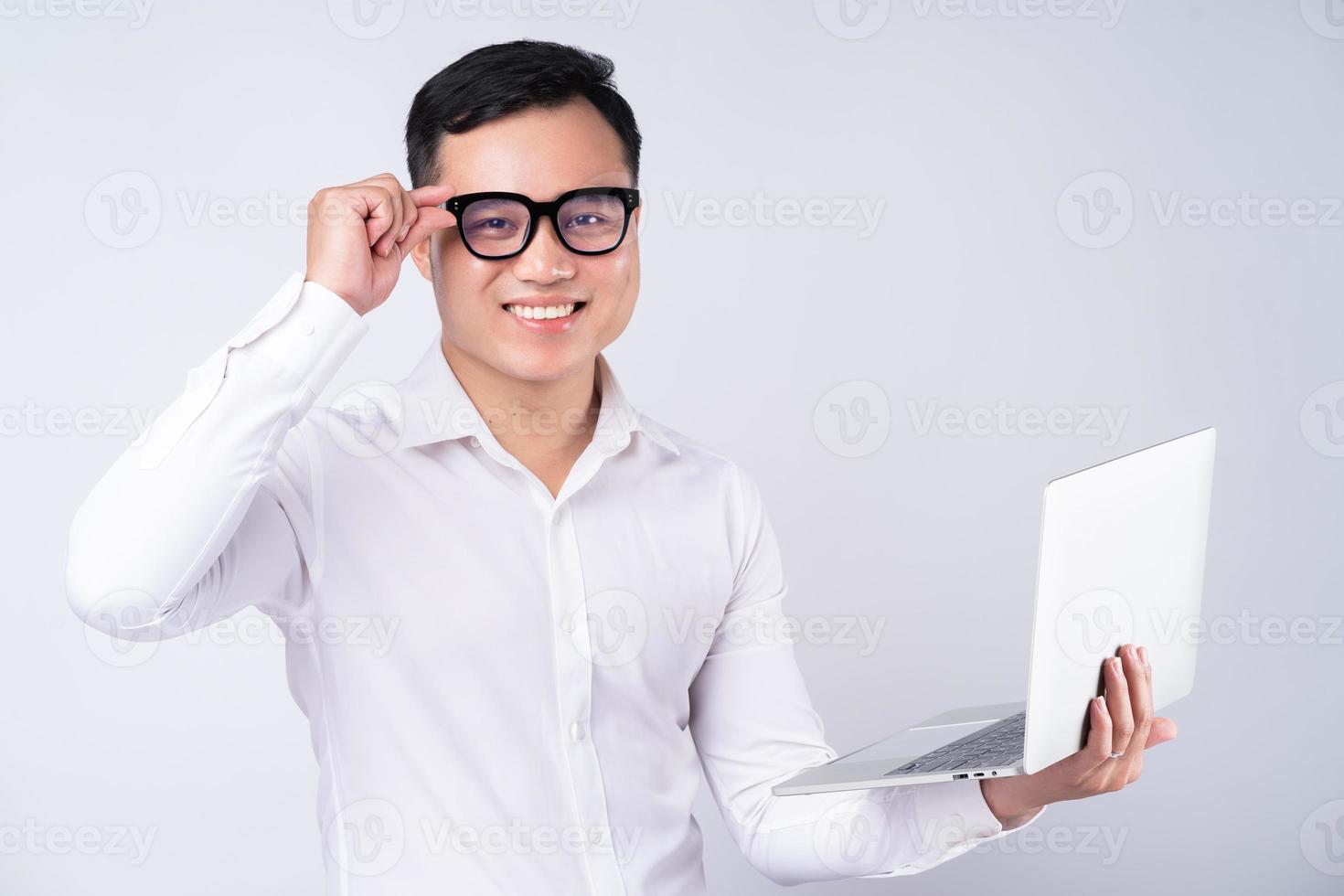 asiatischer Geschäftsmann mit Laptop auf weißem Hintergrund foto