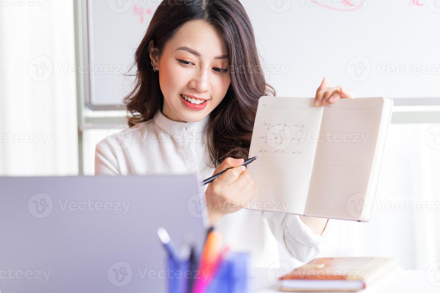 asiatische Lehrerin, die zu Hause online unterrichtet foto