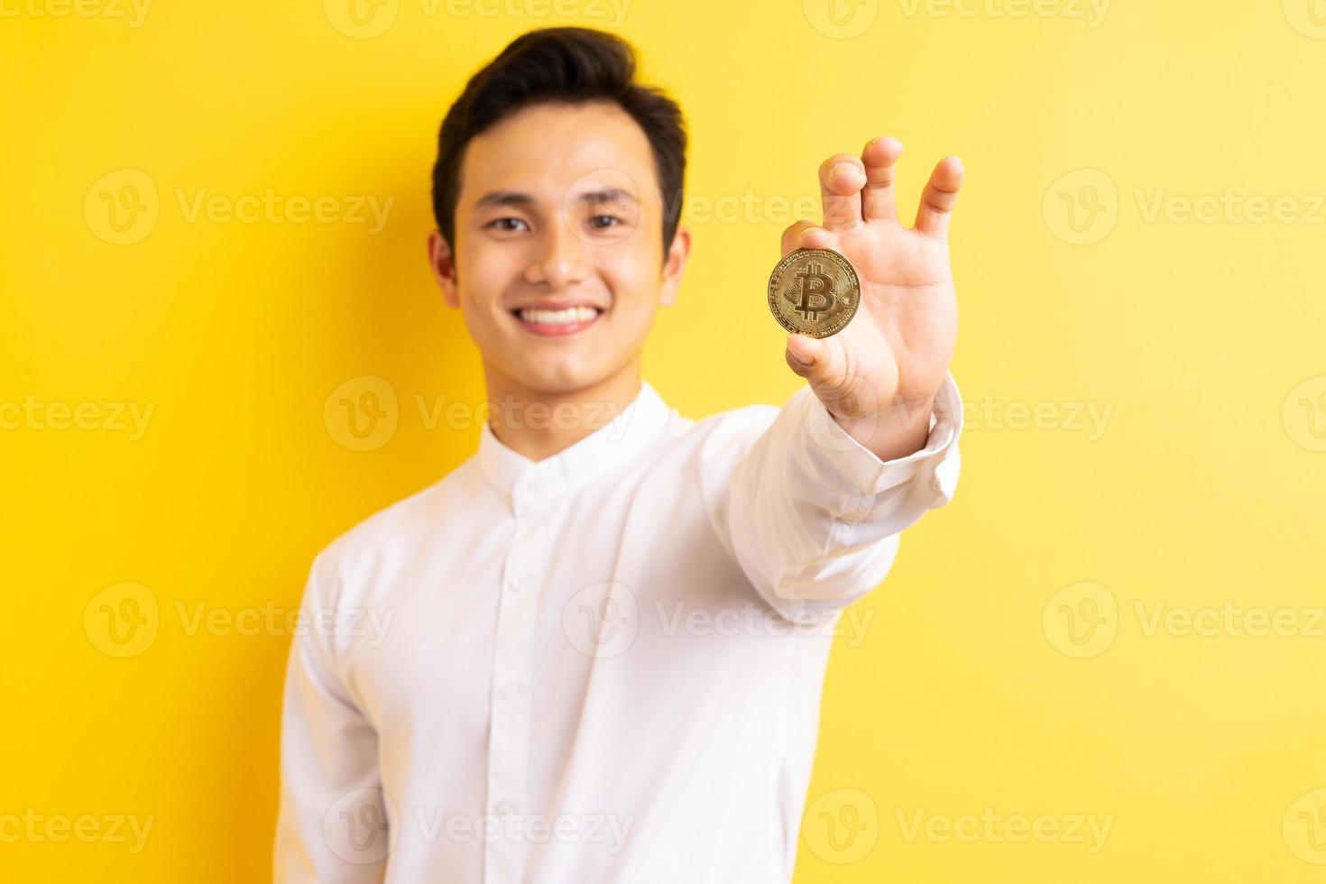 Asiatischer Geschäftsmann, der Bitcoin in der Hand hält, wite glückliches Gesicht foto