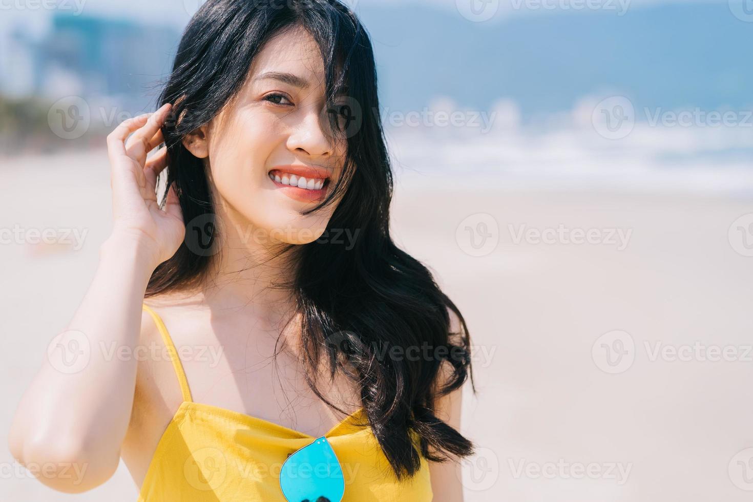 junge asiatische frau, die den sommerurlaub am strand genießt foto