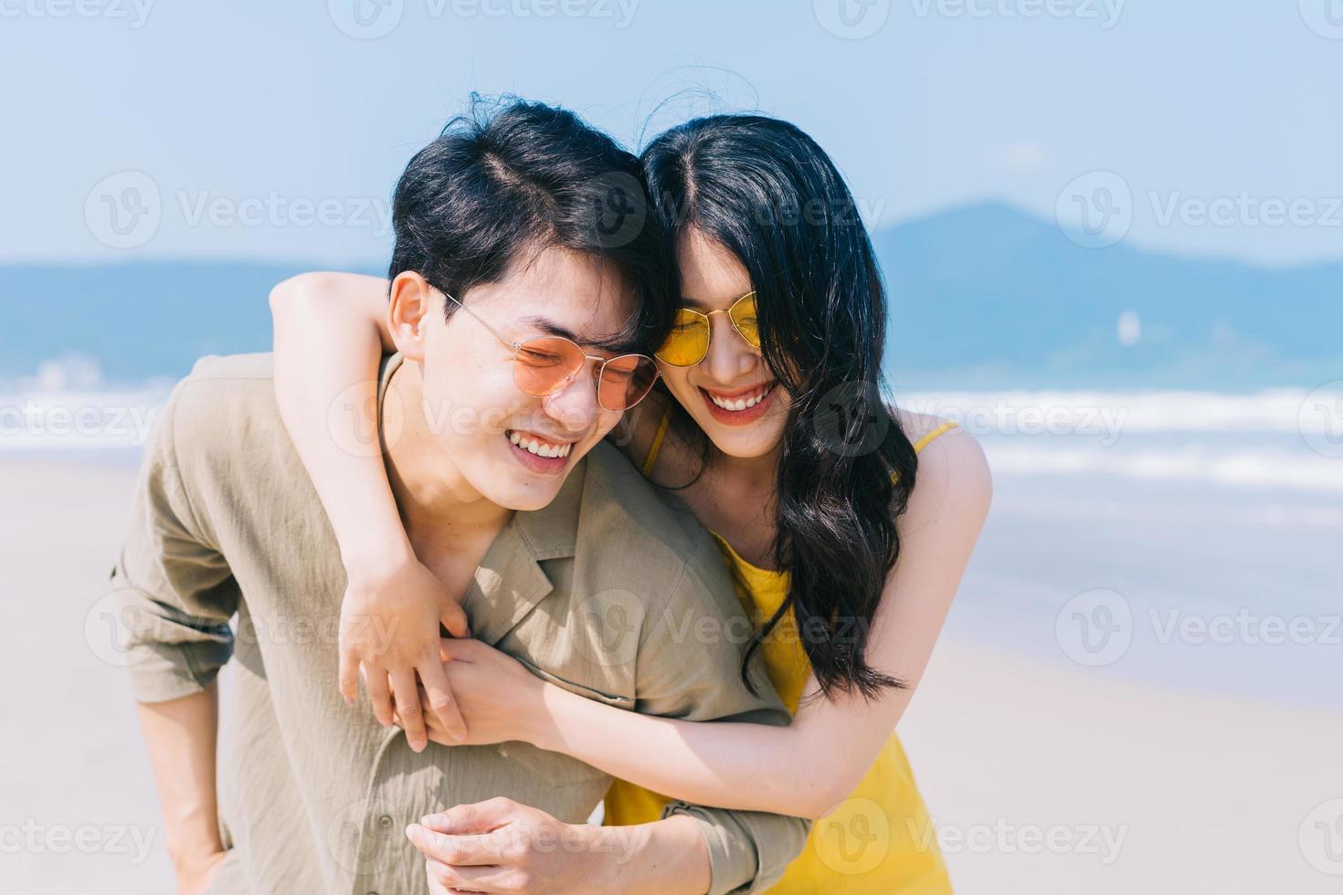 junges asiatisches paar genießen den sommerurlaub am strand enjoying foto