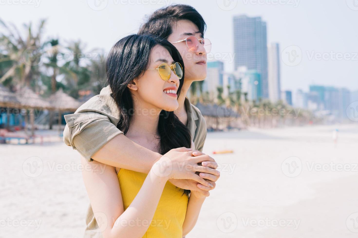 junges asiatisches paar genießen den sommerurlaub am strand enjoying foto