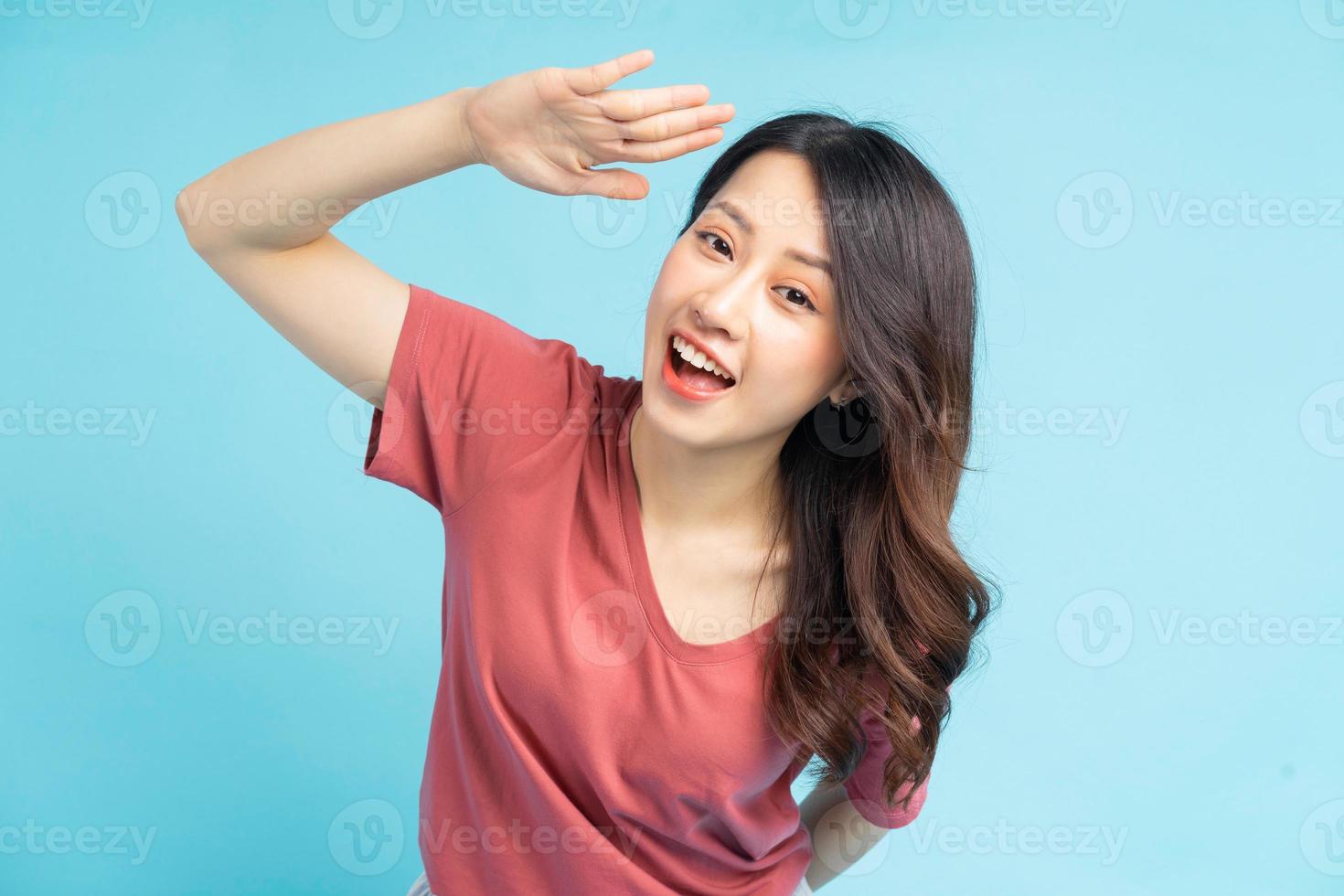 die schöne asiatische frau hielt ihre hand hoch um hallo zu sagen foto