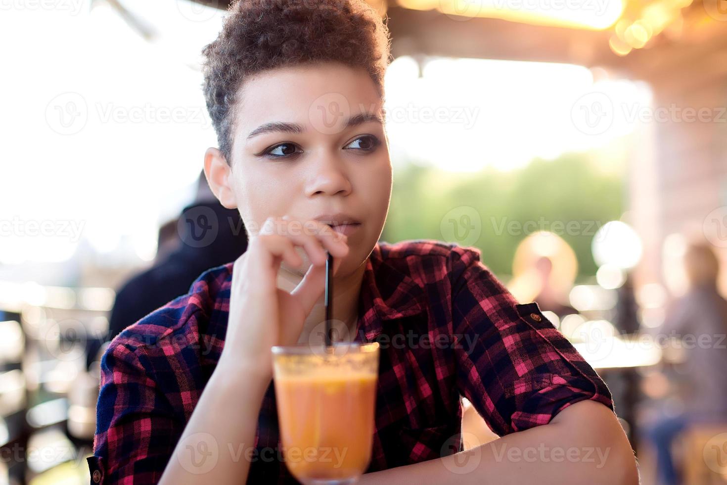 schöne afroamerikanische frau mit kurzen haaren im sommer auf der straße foto