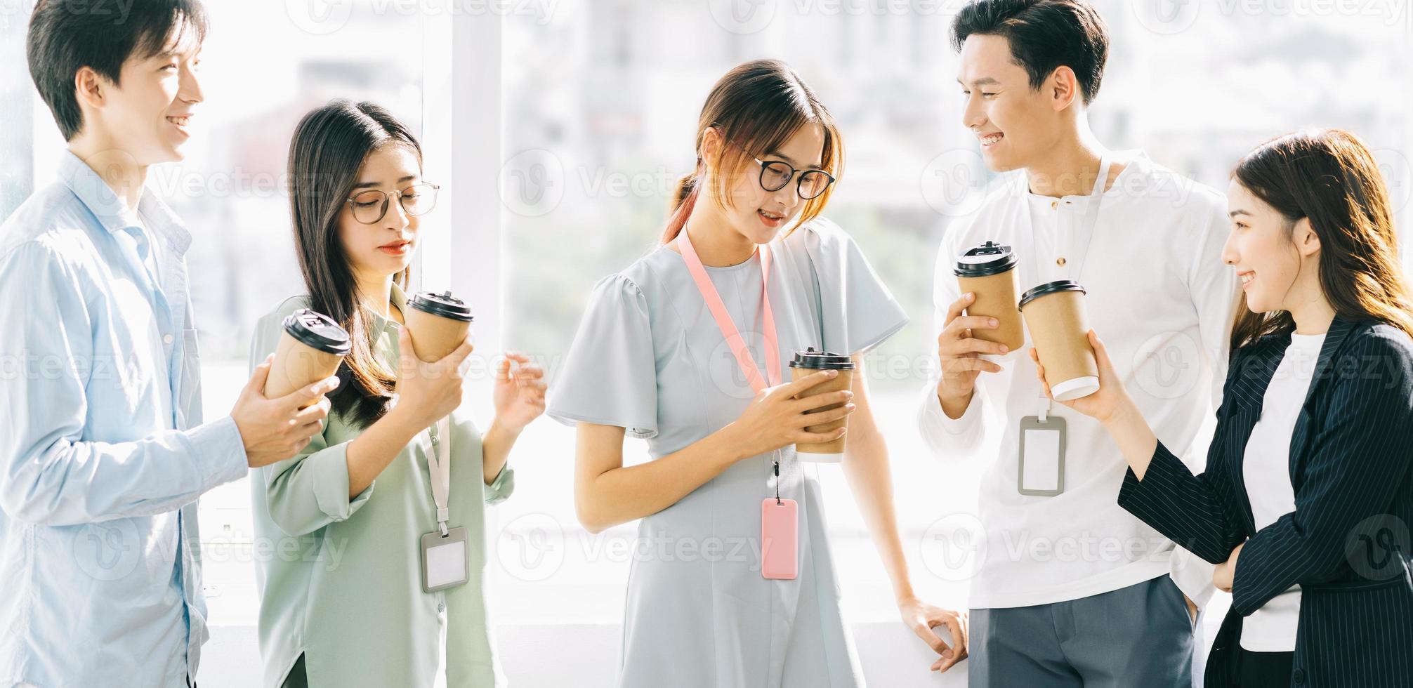 Gruppe von Geschäftsleuten plaudert und trinkt Kaffee während der Pause foto