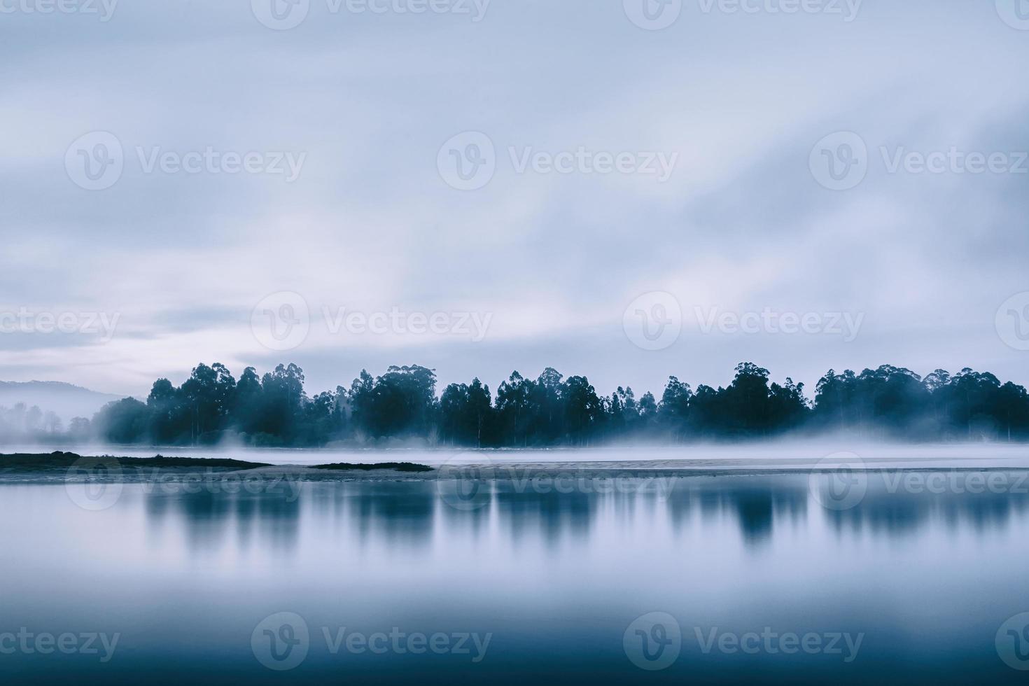 Bäume am Ufer eines Flusses bei Sonnenaufgang foto