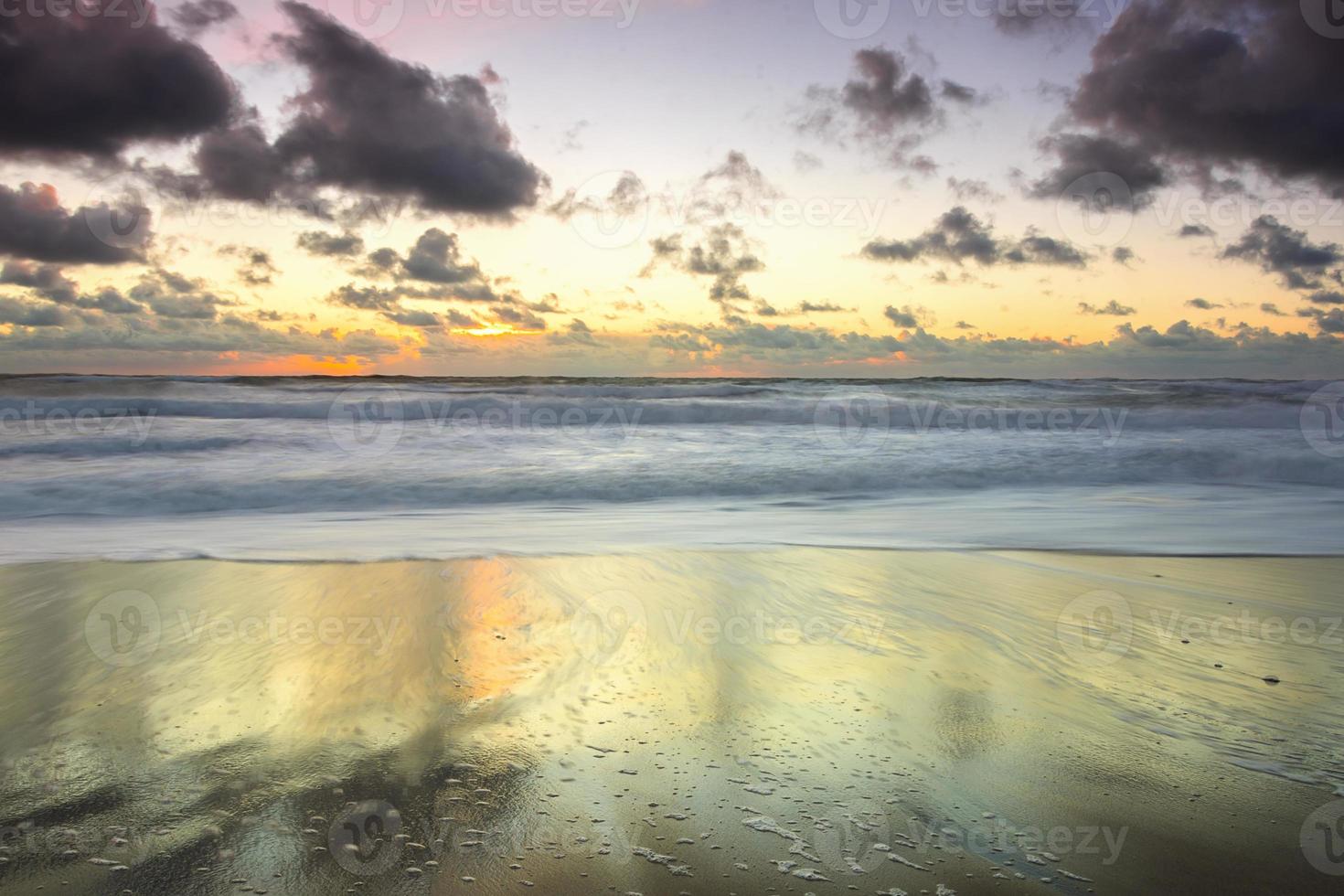 ruhiger Sonnenuntergang am Strand nach einem Sturm foto