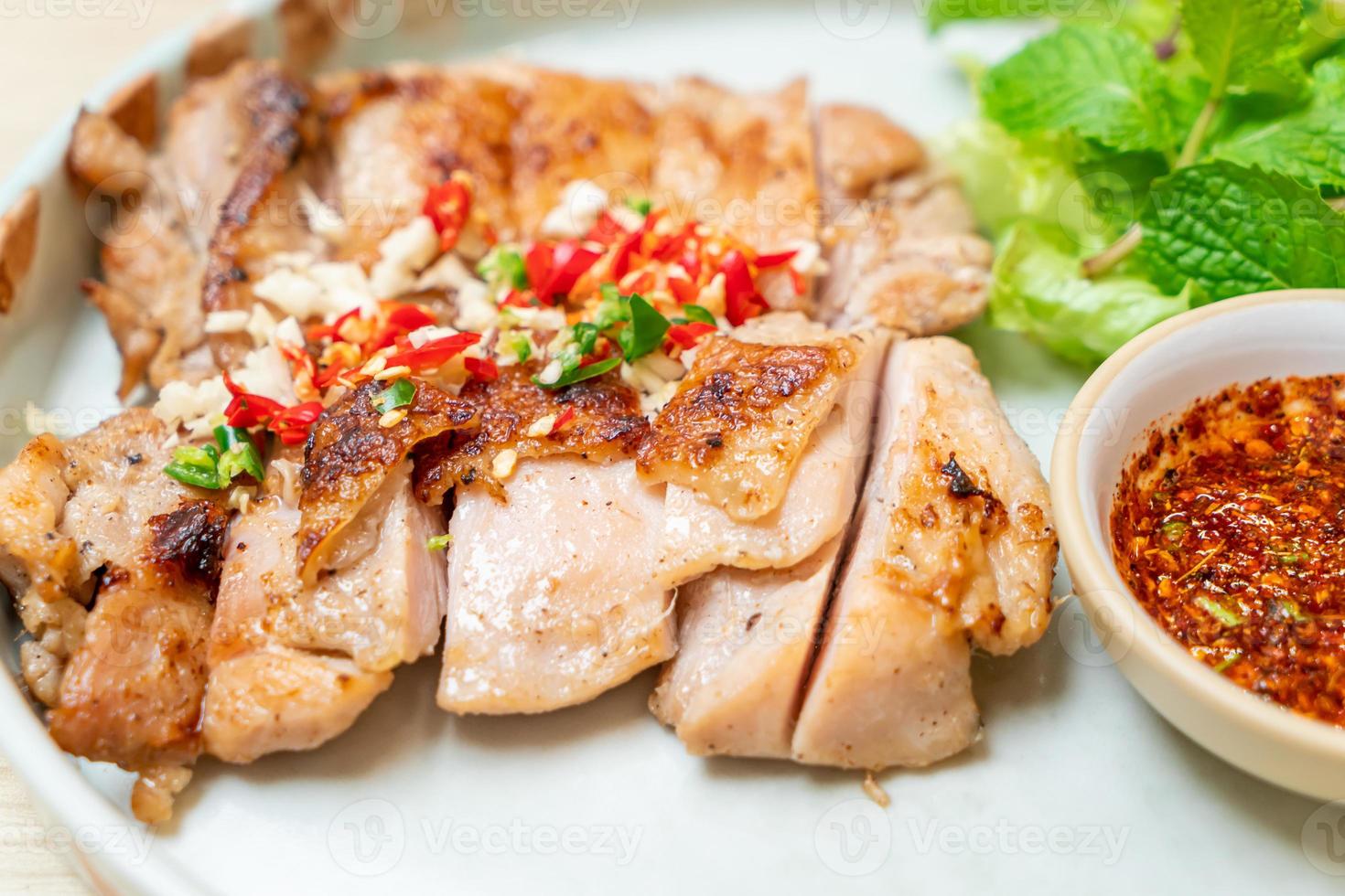 herzhaft gegrilltes Hähnchen mit Chili und Knoblauch auf einem Teller foto