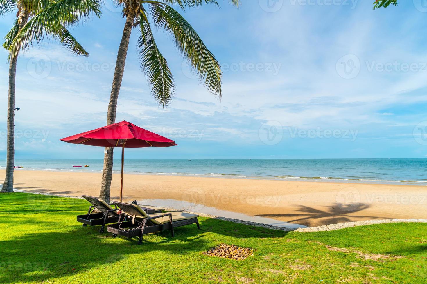 Sonnenschirm und Stühle mit Meerblick im Hotelresort für Urlaubsreisekonzept foto