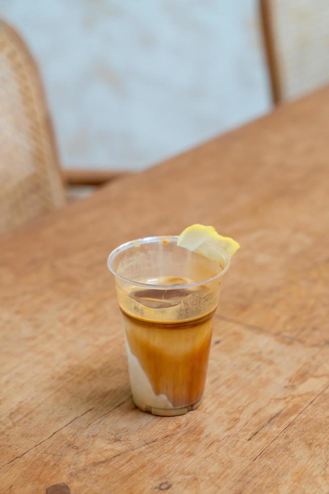 Spezialitätenkaffee-Menü namens "schmutziger Kaffee". unten kalte Milch mit einem heißen Espresso obenauf mit Zitrone foto