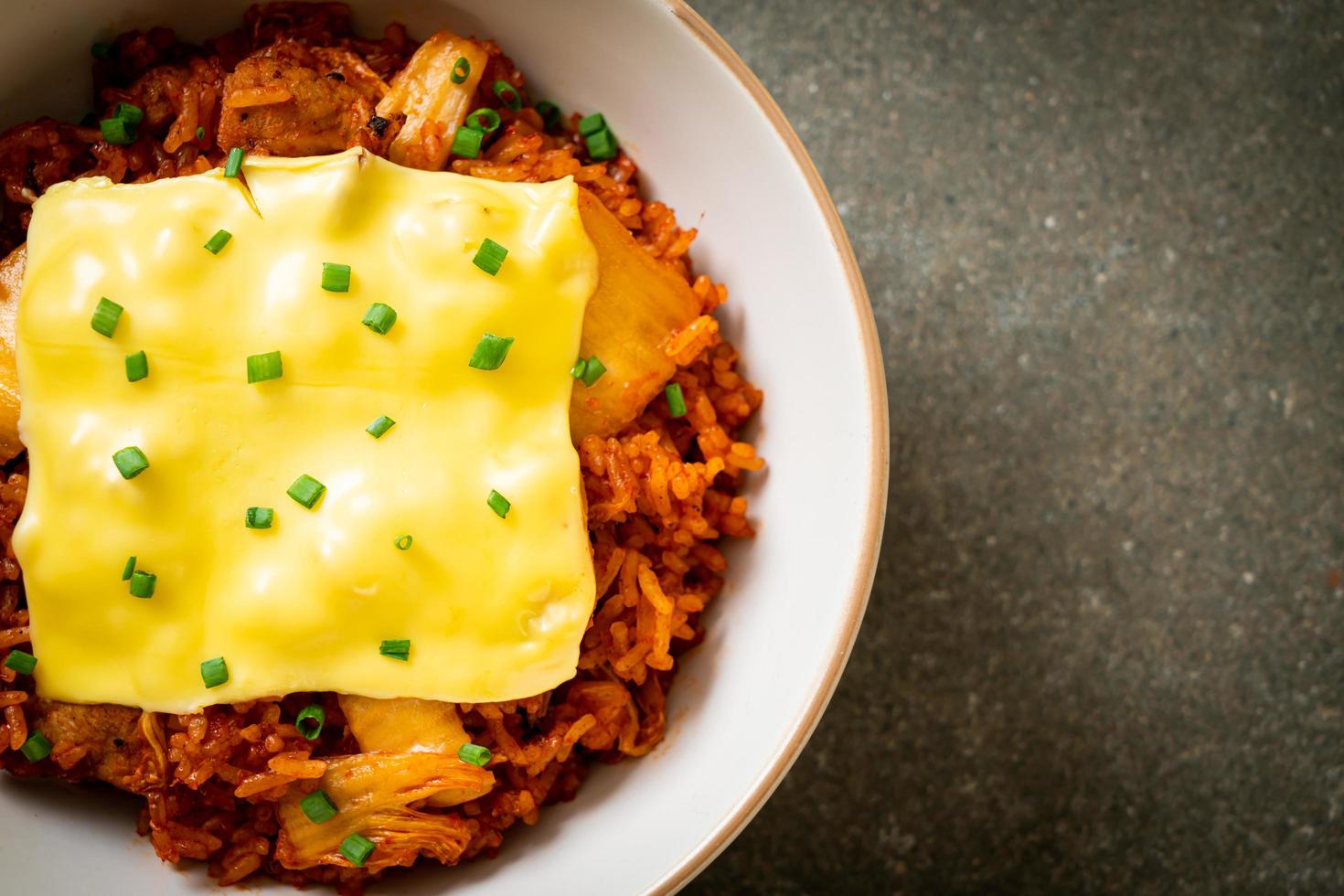 gebratener Kimchi-Reis mit Schweinefleisch und belegtem Käse - asiatisch und Fusion-Food-Stil foto