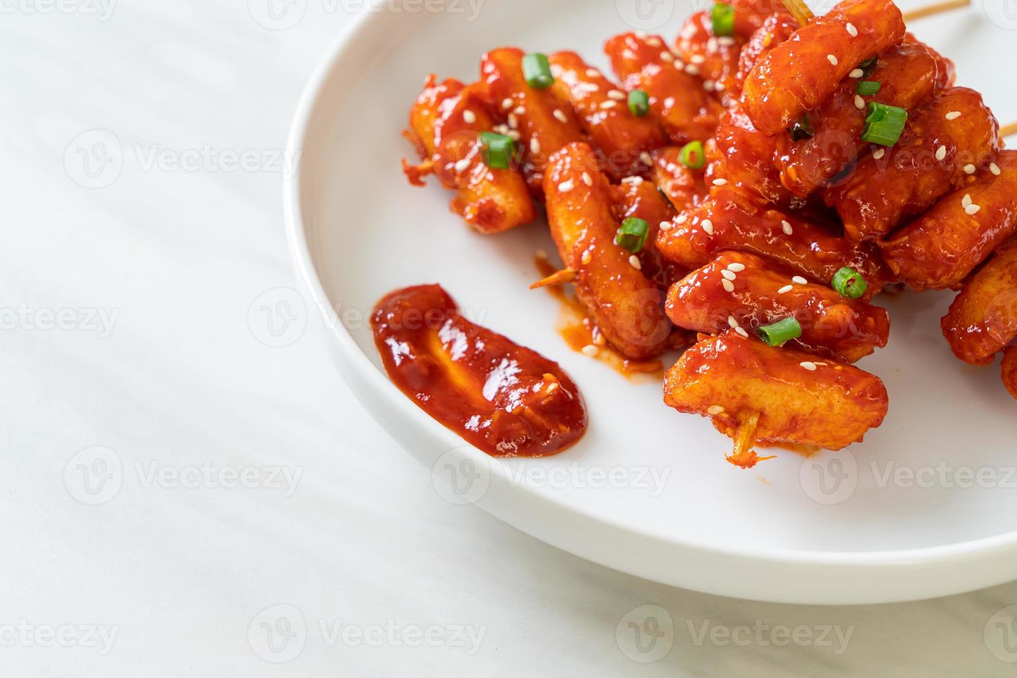 frittierter koreanischer Reiskuchen oder Tteokbokki, aufgespießt mit scharfer Sauce - koreanische Küche food foto