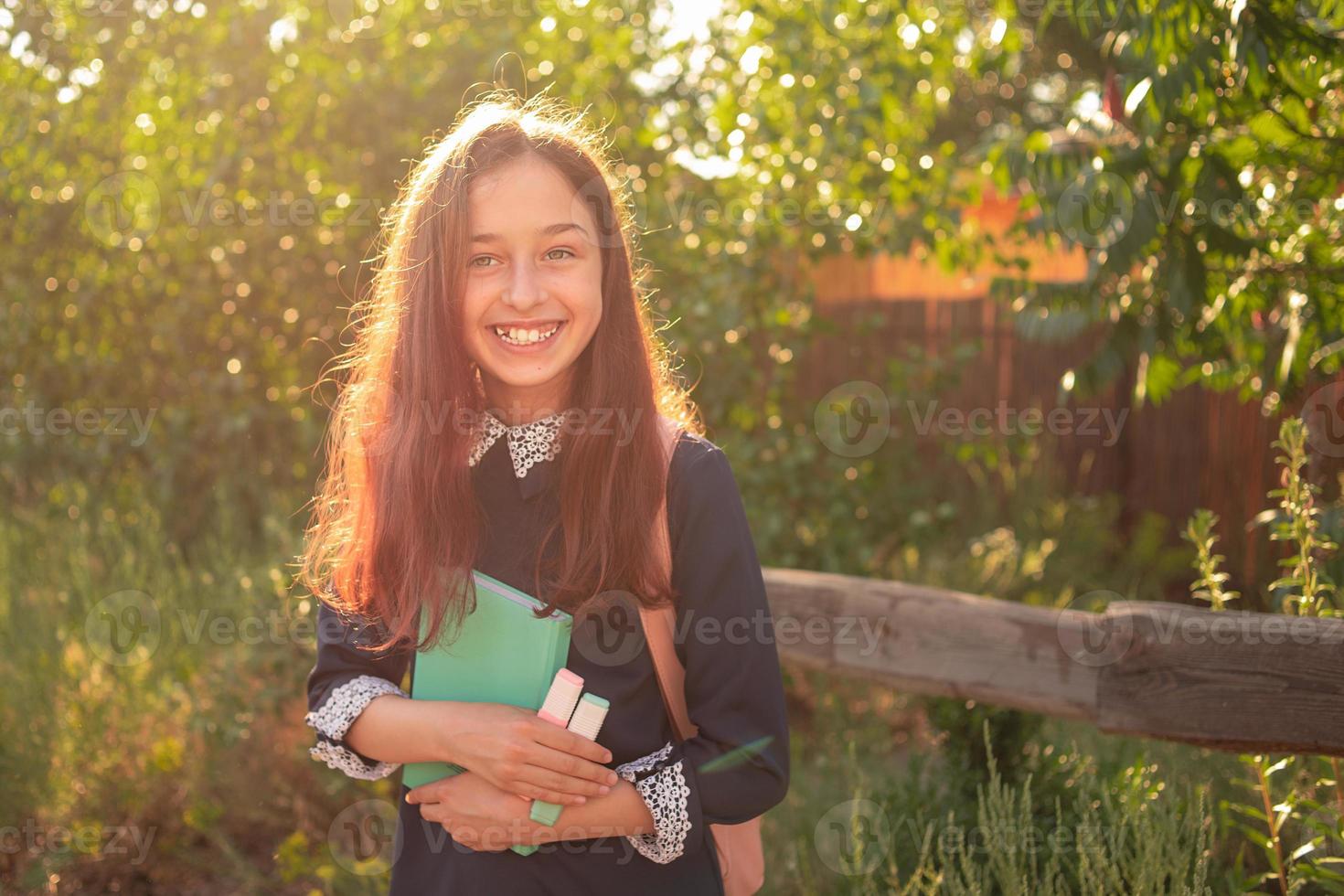 hübsches junges Mädchen mit Rucksack und Notizblock. Schulmädchen Teenager Mädchen lächelnd mit Notizblock. foto