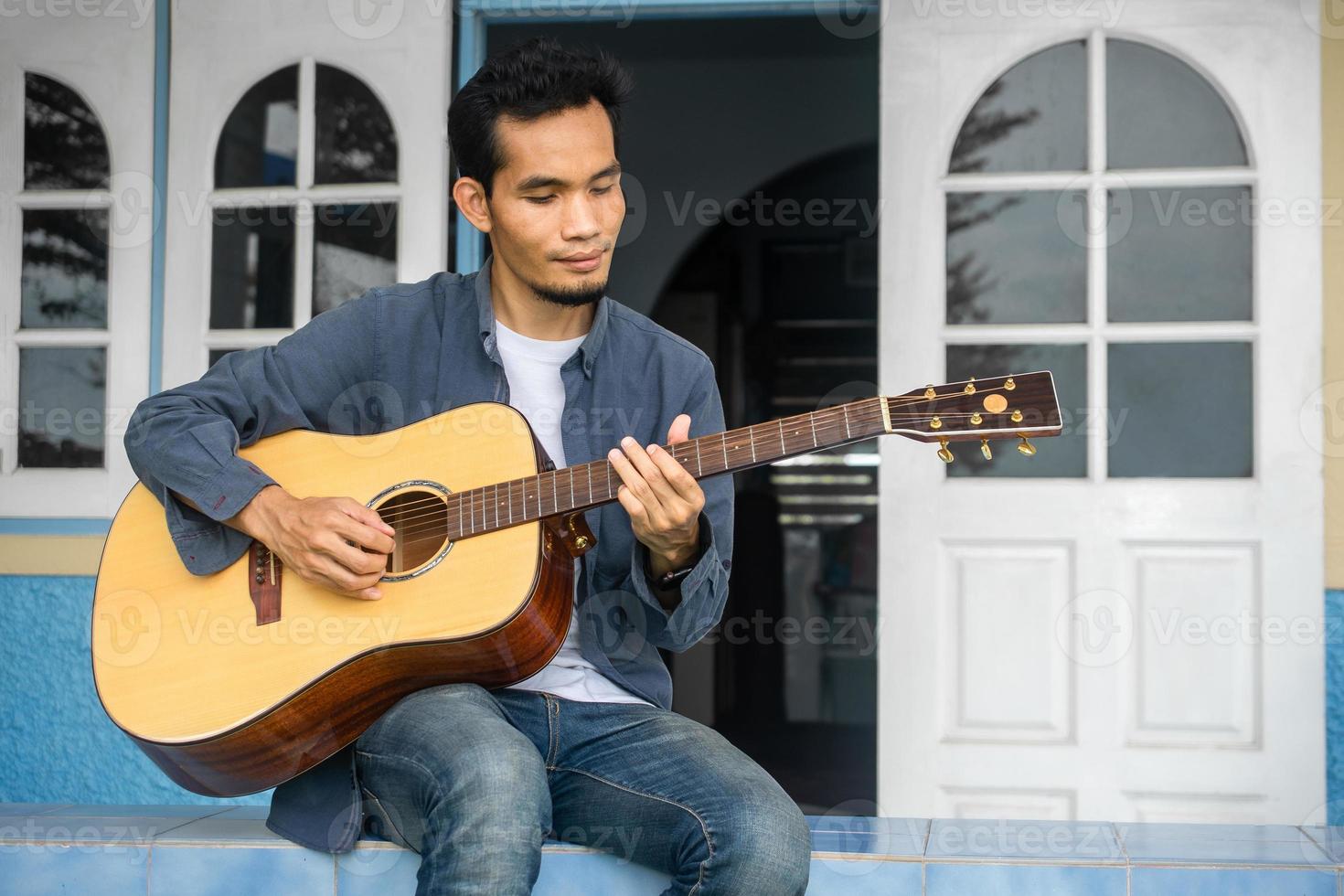 Mann spielt Gitarre glückliche Freizeit zu Hause foto