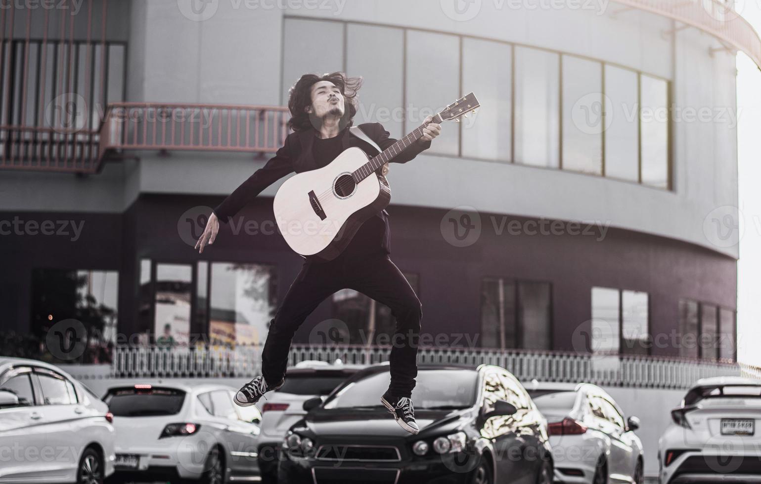 Mann singt Lied und spielt Gitarre im Freien foto