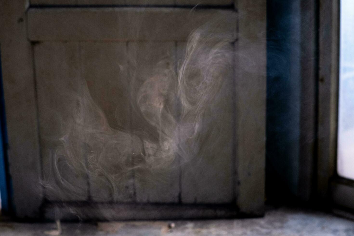 ein Ohnmacht Wolke von Rauch trieb Vergangenheit das Tür, geben ein klar Sicht. foto