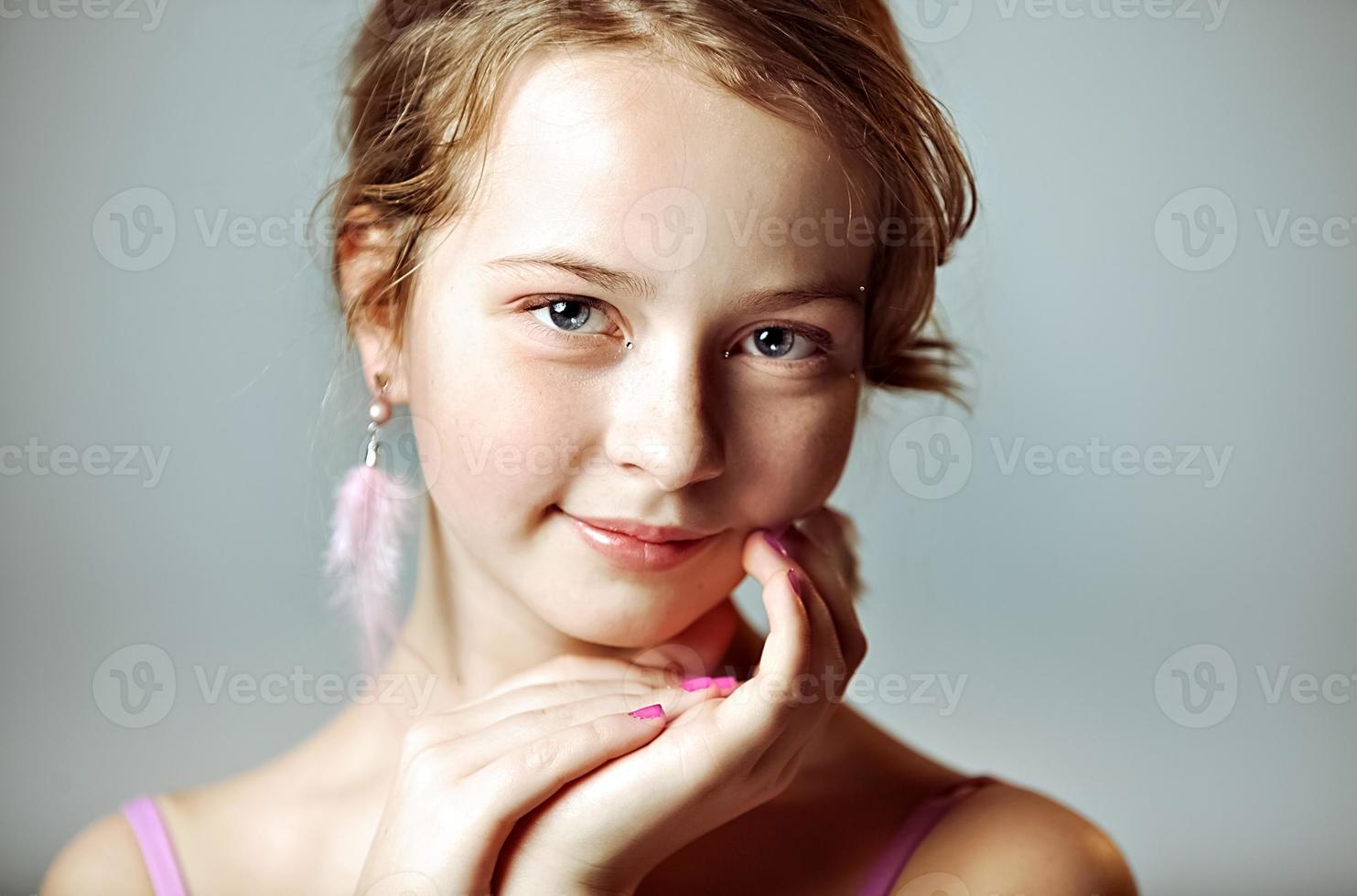 Nahaufnahmeporträt eines jungen Mädchens mit festlichem Make-up für eine Party. Valentinstag. Ohrringe-Federn in den Ohren des Models foto