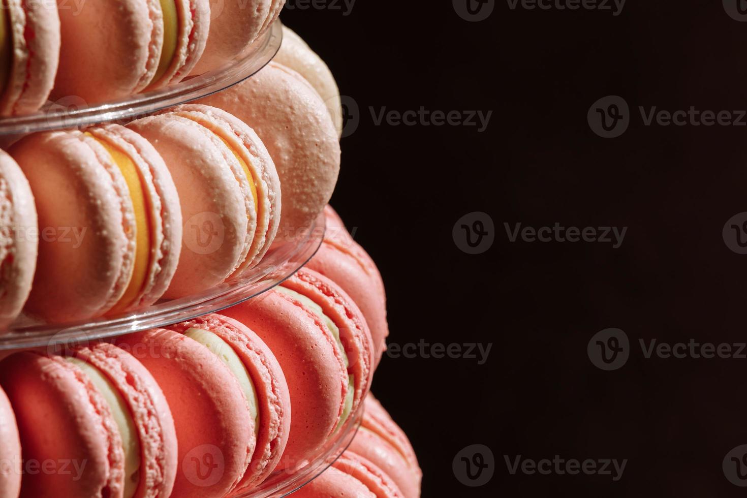 süße Pyramide der französischen Macarons oder Makronen zum Geburtstag, Event oder Hochzeit auf schwarzem Hintergrund. selektiver Fokus. Platz kopieren. foto