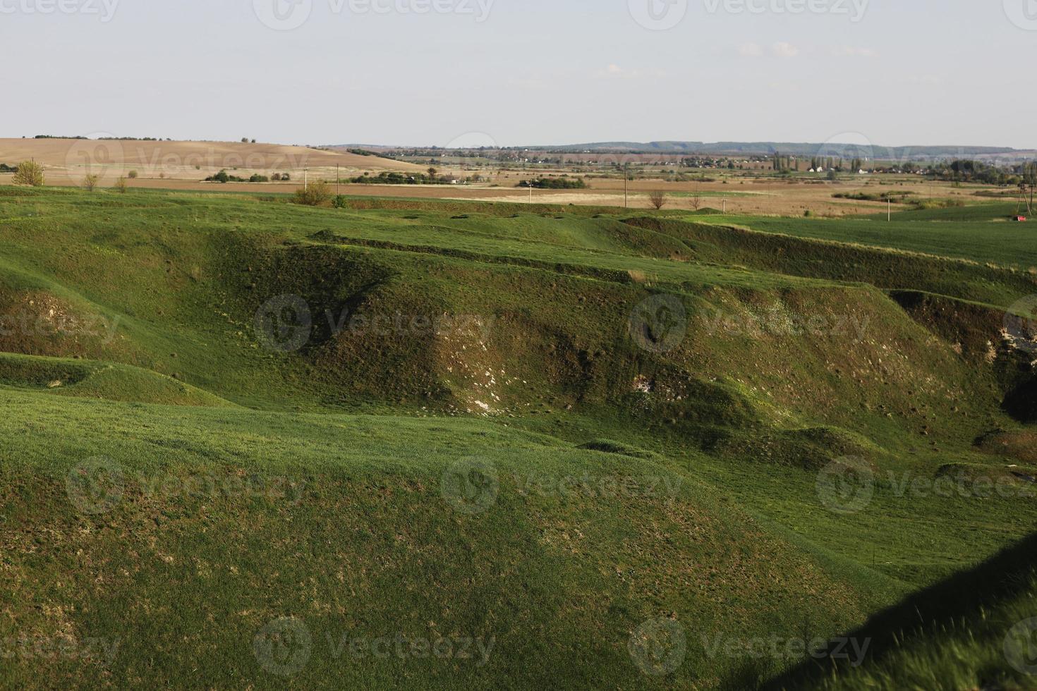 Landschaft Felder und Wiesen auf Hügeln im Sommer. idyllische Berglandschaft an einem sonnigen Tag. Landschaft rollt in den fernen Kamm. wunderbares Wetter mit flauschigen Wolken am blauen Himmel. foto