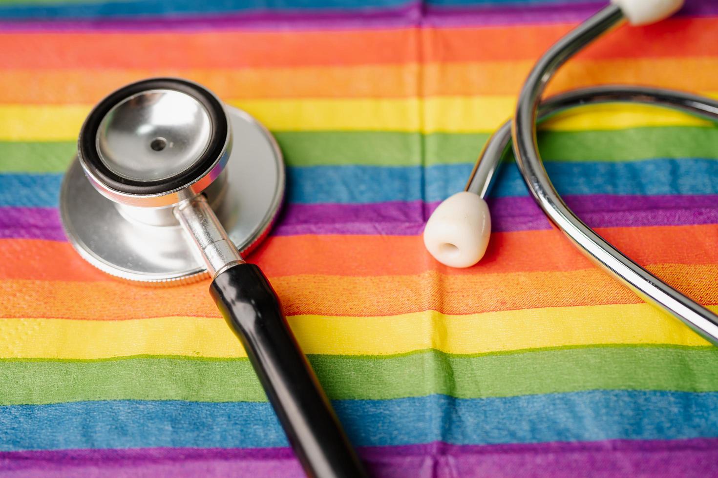schwarzes stethoskop auf regenbogenflaggenhintergrund, symbol des lgbt-stolzmonats feiern jährlich im juni sozial, symbol für schwule, lesbische, bisexuelle, transgender, menschenrechte und frieden. foto