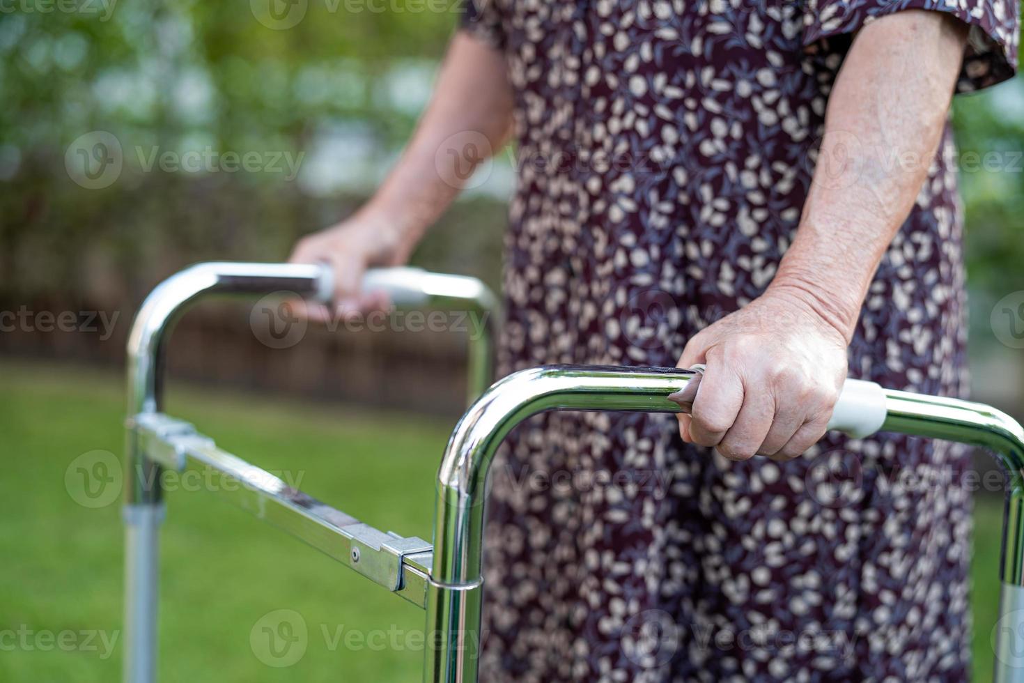asiatische Senioren oder ältere alte Damenpatienten gehen mit Walker im Park, gesundes, starkes medizinisches Konzept. foto