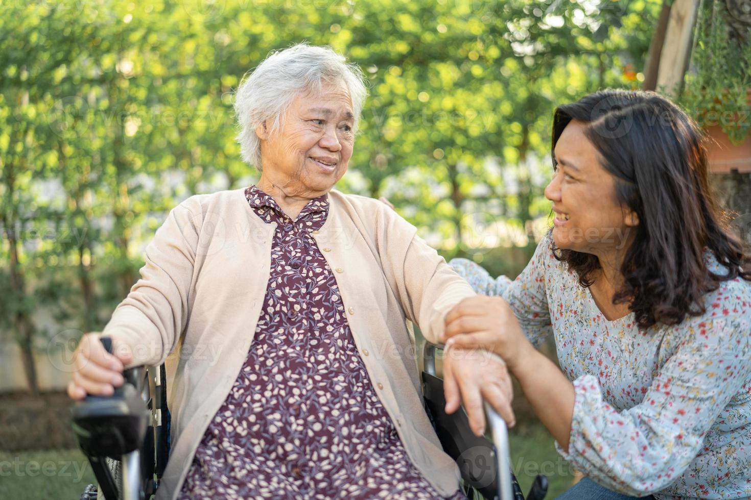 Hilfe und Pflege asiatische Senioren oder ältere Frauenpatienten, die auf Rollstuhl im Park in der Krankenstation sitzen, gesundes, starkes medizinisches Konzept. foto