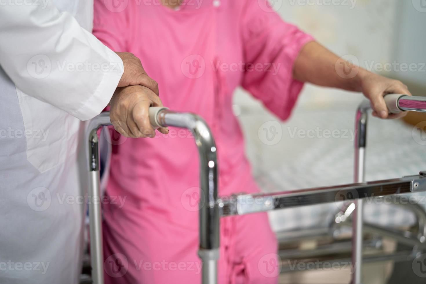 asiatische krankenschwester physiotherapeut arztpflege, hilfe und unterstützung älterer oder älterer alter frauenpatienten gehen mit walker auf der krankenstation, gesundes starkes medizinisches konzept. foto