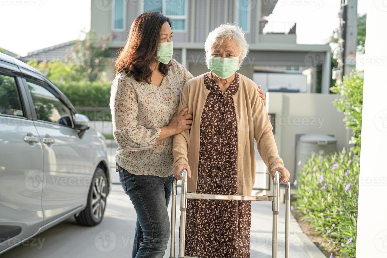 asiatische senior oder ältere alte dame gehen mit walker und tragen eine gesichtsmaske zum schutz der sicherheitsinfektion covid-19 coronavirus. foto