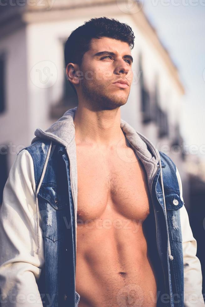 hübscher junger Mann mit blauen Augen posiert im städtischen Hintergrund foto