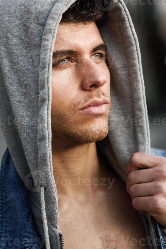 hübscher junger Mann mit blauen Augen im städtischen Hintergrund foto