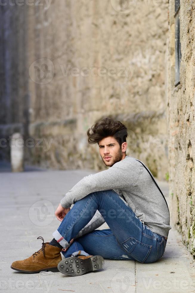 Mann mit Hosenträgern im städtischen Hintergrund foto