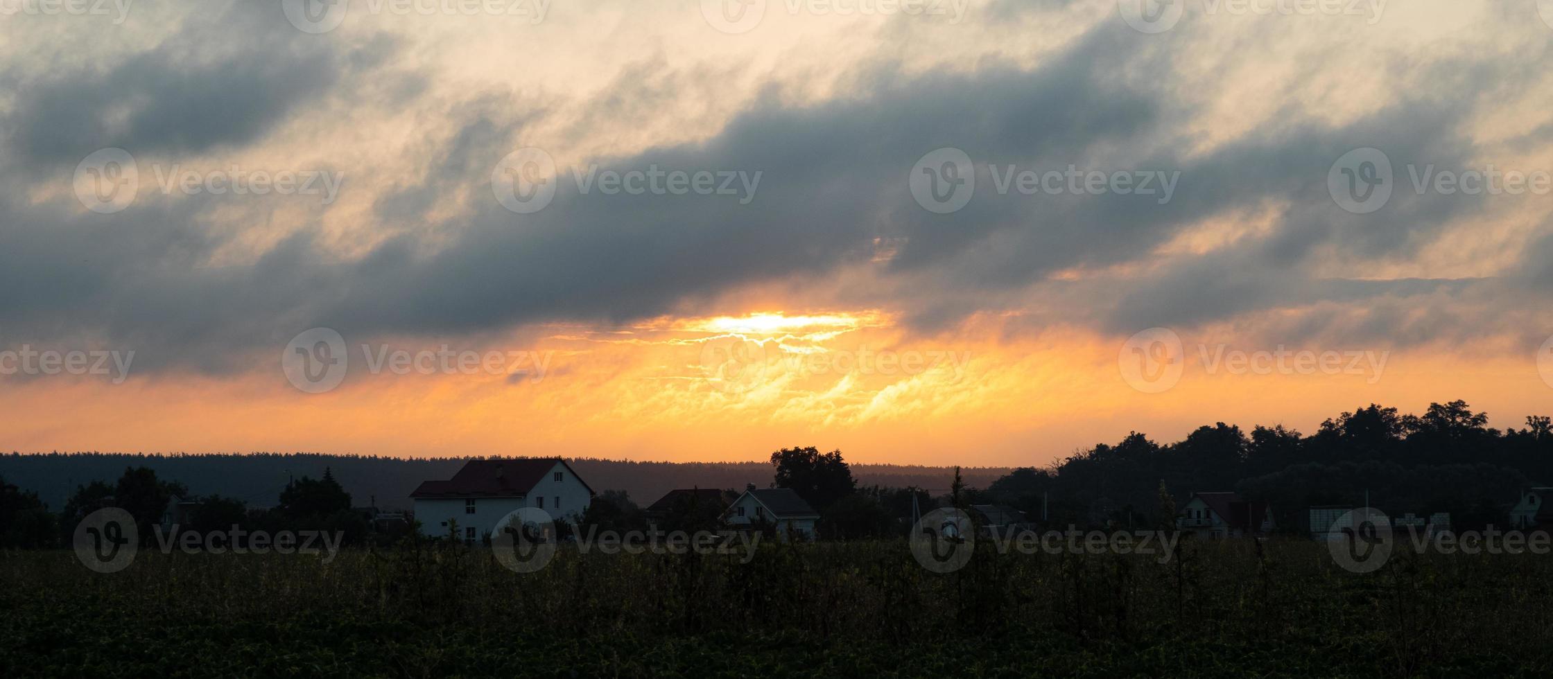 Morgensonnenaufgang über dem Dorf, die erwachende orangefarbene Sonne außerhalb der Stadt foto