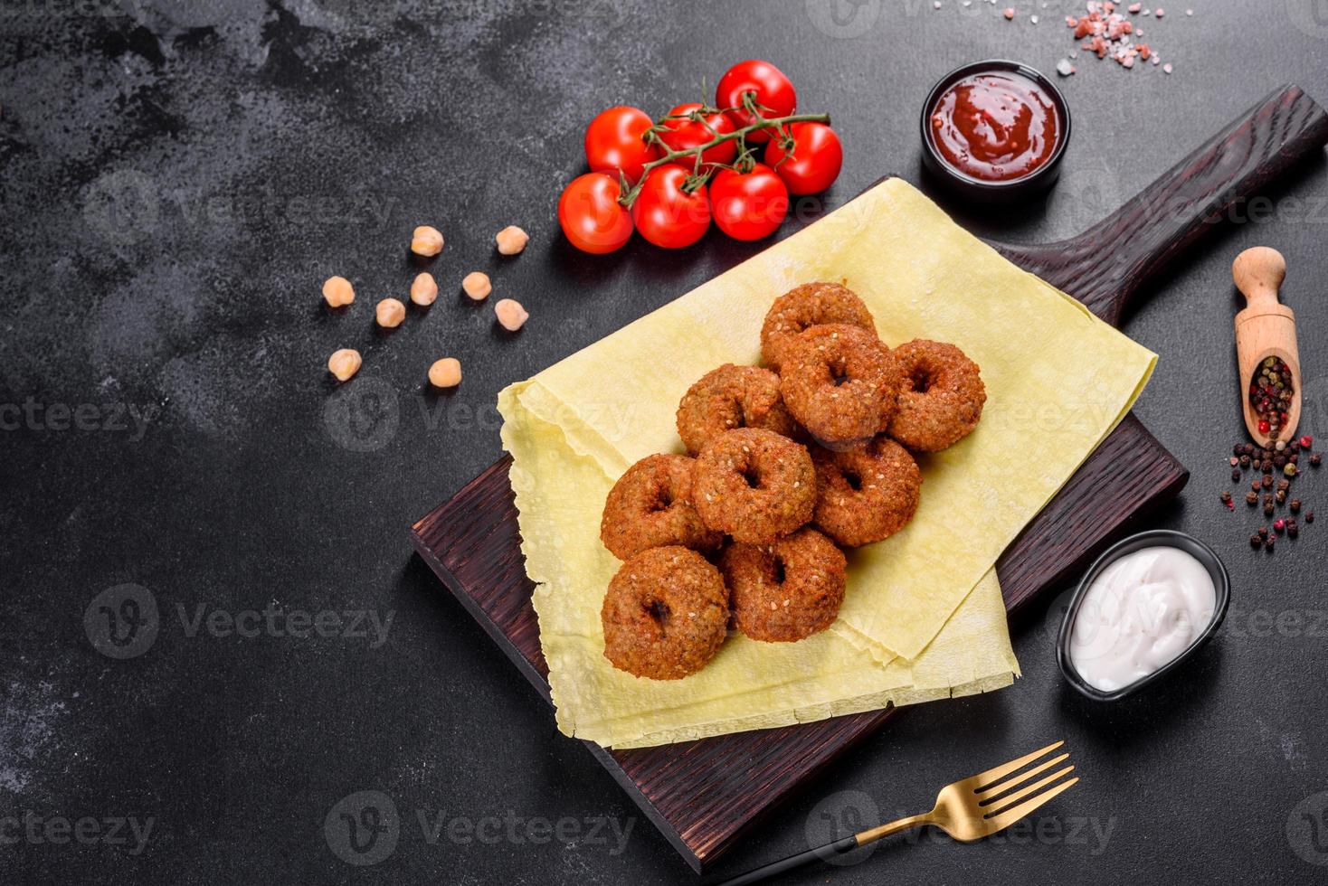 schöne leckere frische Kichererbsen-Falafel mit Saucen auf Betonuntergrund foto