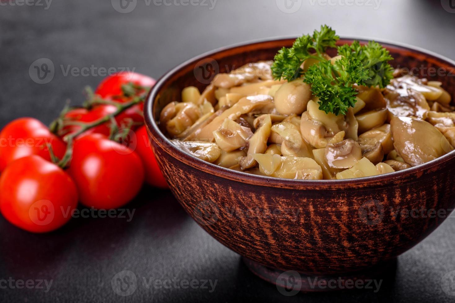 frische leckere würzige Dosenpilze mit Gewürzen und Kräutern in Keramikschalen foto