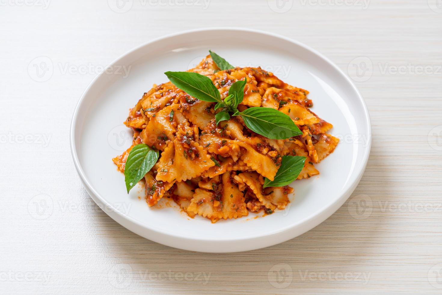 Farfalle Nudeln mit Basilikum und Knoblauch in Tomatensauce - italienische Sauce foto