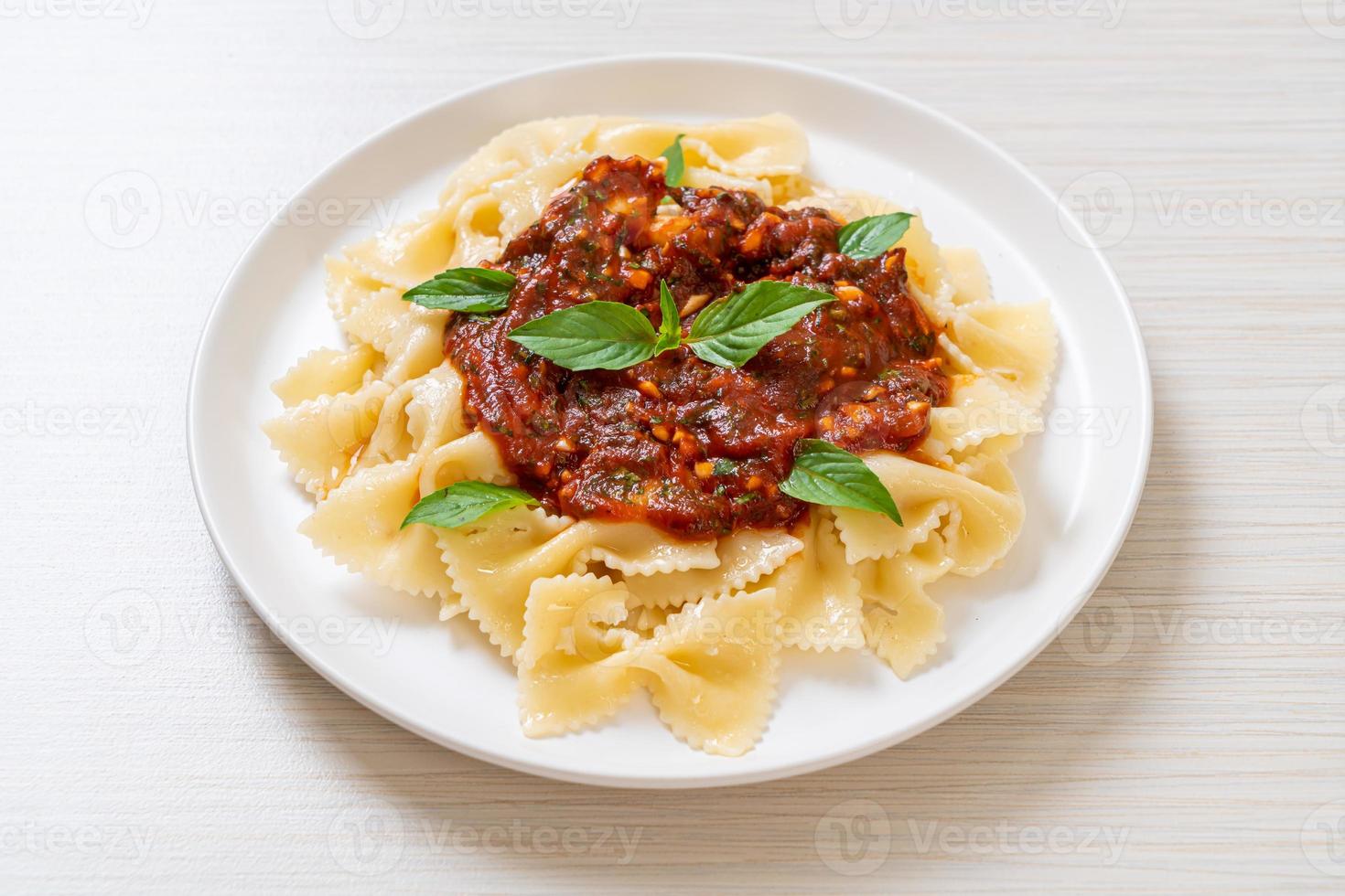 Farfalle Nudeln mit Basilikum und Knoblauch in Tomatensauce - italienische Sauce foto